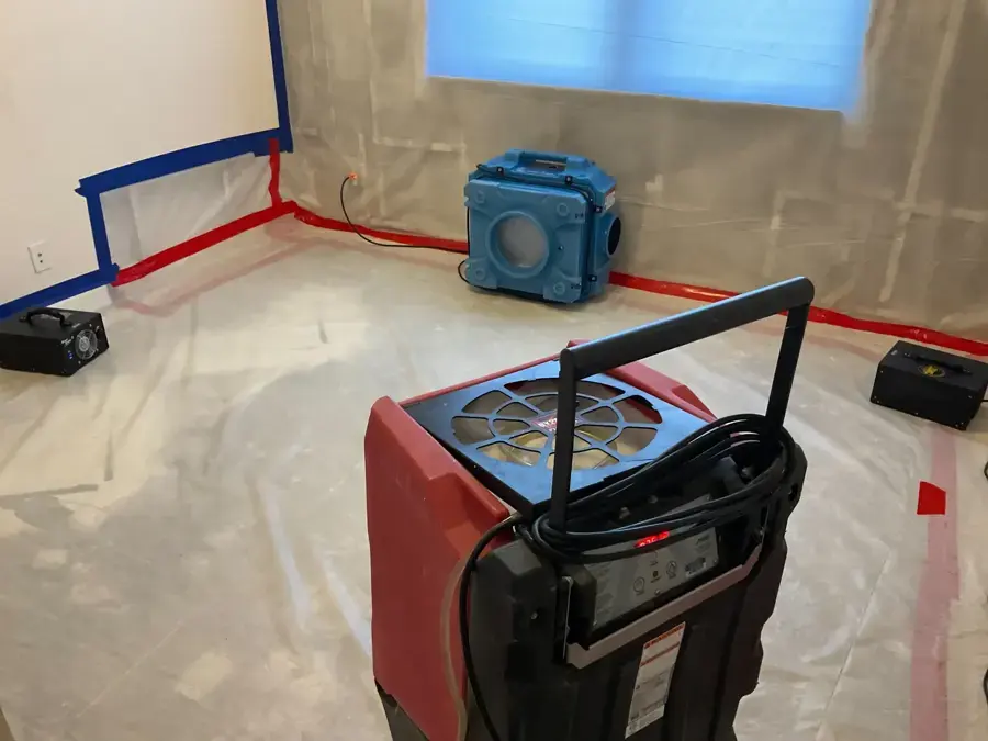 Dehumidifier and air scrubber running inside plastic containment during a water damage dry-out in Matthews, NC